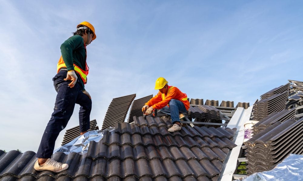 2-construction-workers-install-new-roof-construction-site-electric-drill-used-new-roofs-with-concrete-roof-tiles-concept-residential-building-construction-min