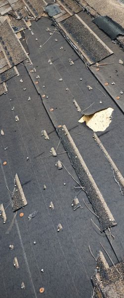 damaged-house-roof-with-missing-shingles-after-hurricane-ian-florida-consequences-natural-disaster-min